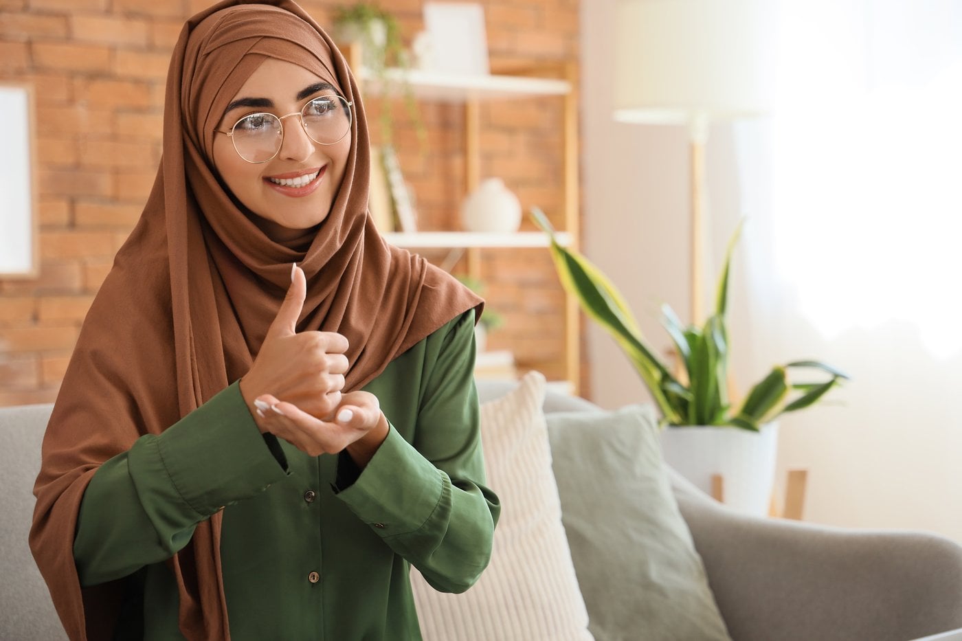 Woman in hijab giving thumbs up showing culturally safe support