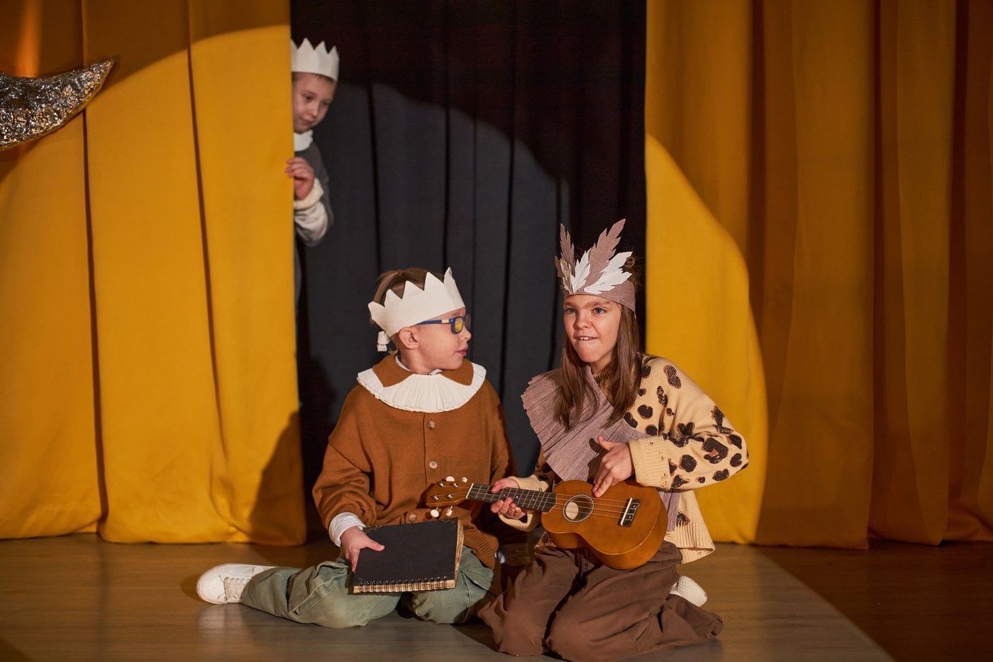 Children in costumes performing together on stage