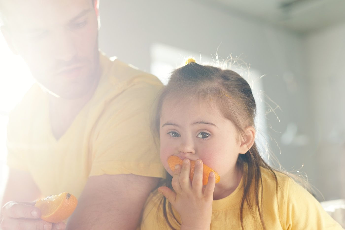 Father and daughter with Down syndrome sharing a meal together