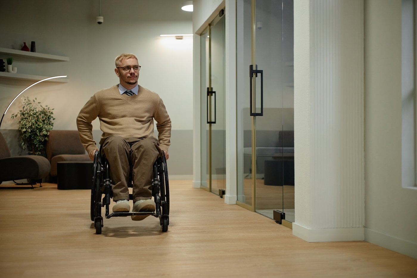 Man in wheelchair navigating a modern accessible workplace