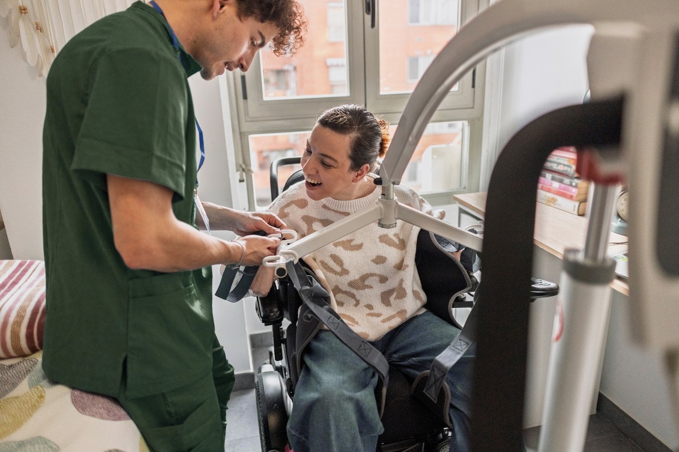 Carer adjusting a hoist harness for a wheelchair user