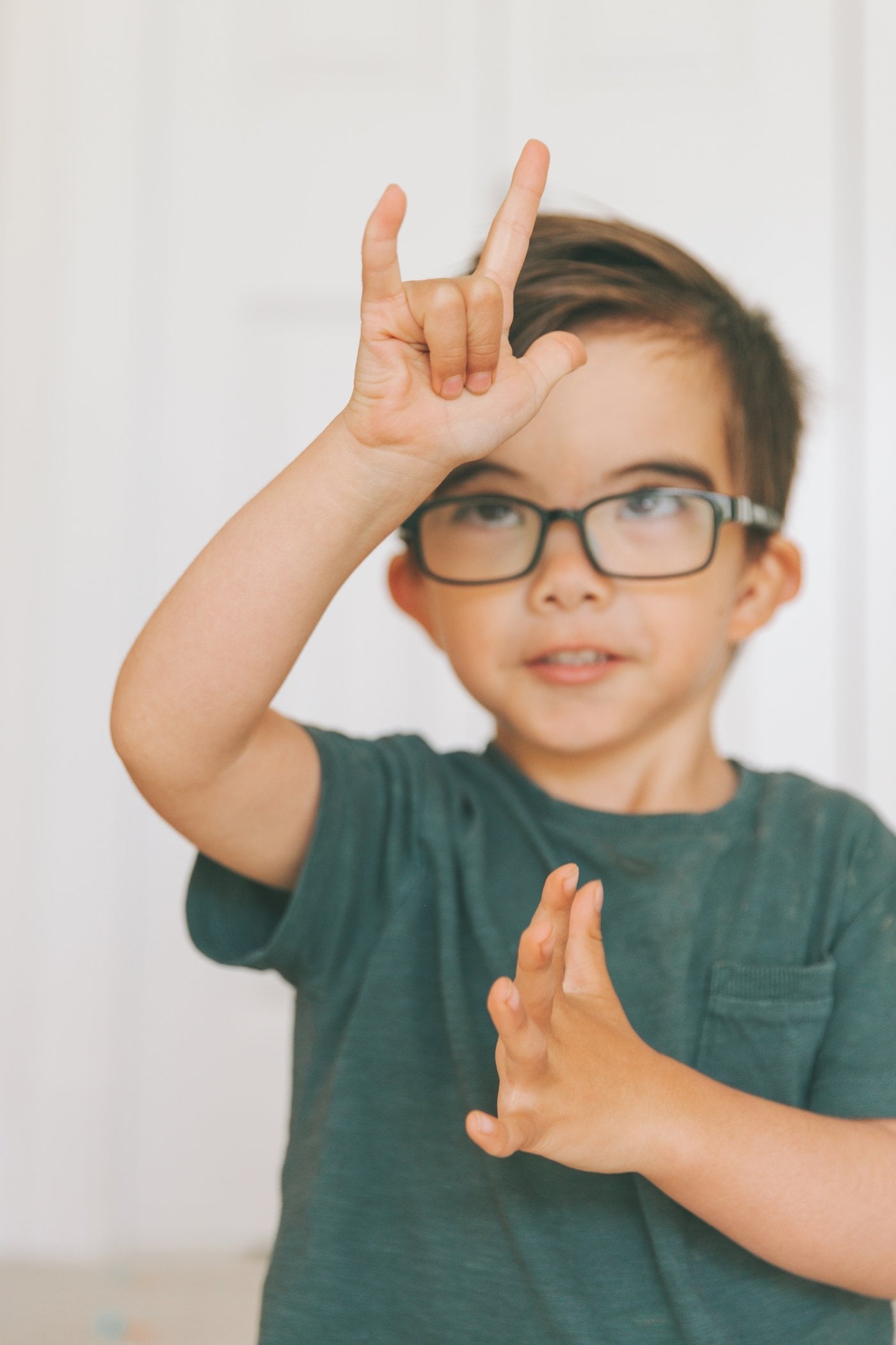 Boy with glasses practising sign language